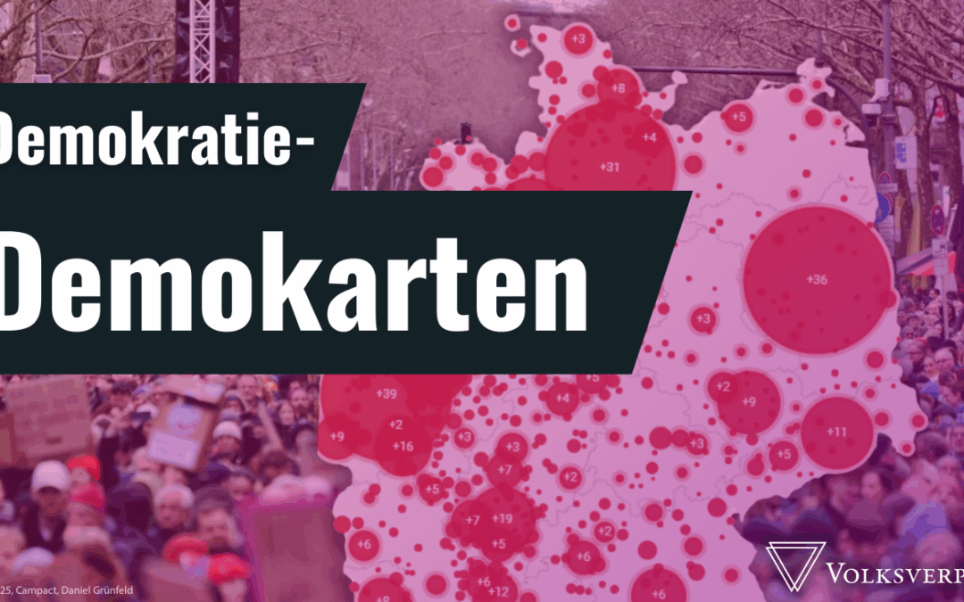 Demokratie-Demokarten steht weiß aufdunkelblauen Balken. Pink überlagert sieht man im Hintergrund eine Deutschlandkarte mit vielen ortsgebundenen Kreisen. Dahinter ein Bild einer großen Demonstration. Unten rechts: Volksverpetzer-Logo in weiß.
